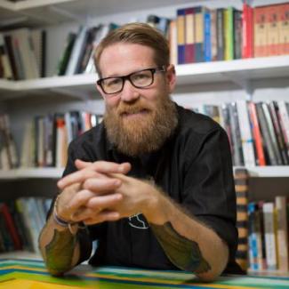 Dr. Heynen poses in front of a bookcase