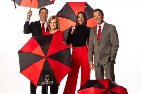 UGA ATSC Alumni pose with red and black umbrellas for a group photo